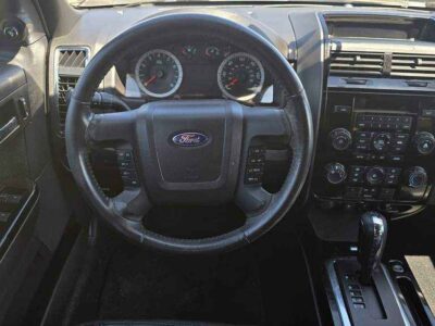 Driver interface detail showcasing the white-faced instrument cluster and leather-wrapped steering wheel.