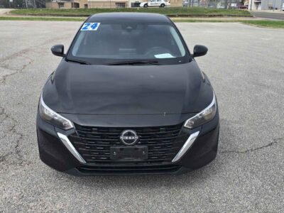 Front Profile: 2024 Nissan Sentra SV showing the modern V-Motion grille and aerodynamic sedan profile.