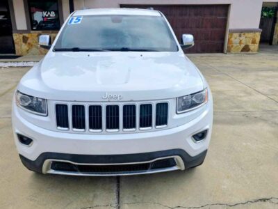 Front Profile: 2015 Jeep Grand Cherokee Limited in Bright White highlighting the signature seven-slot chrome grille and fog lamp architecture.