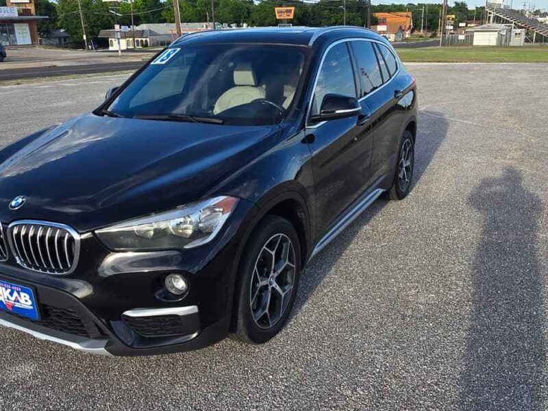Used 2018 BMW X1 sDrive28i luxury compact crossover SUV in Jet Black front profile view at BuskoCars