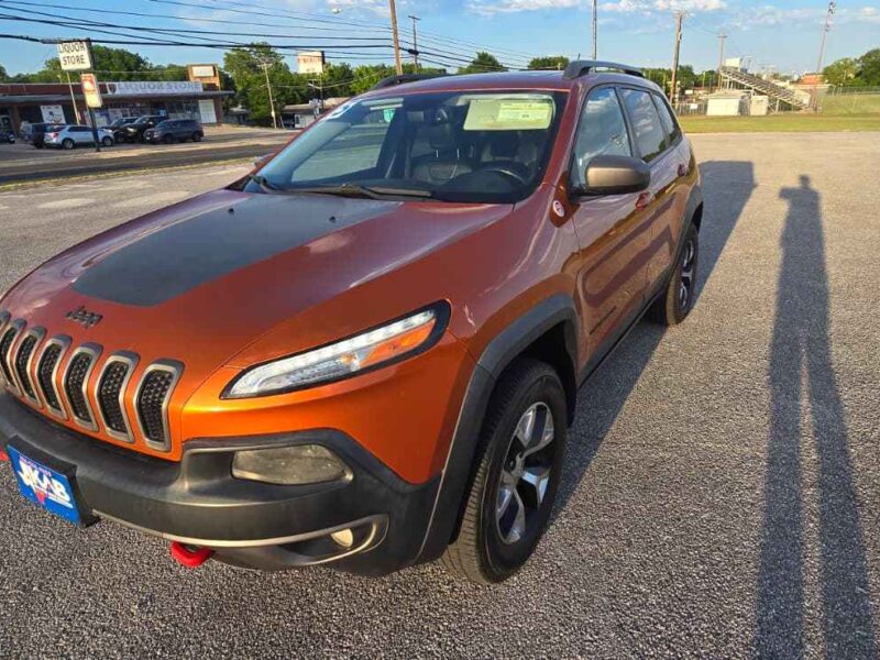 Used 2015 Jeep Cherokee Trailhawk 4WD off-road crossover SUV in Mango Tango Pearl front profile view at BuskoCars