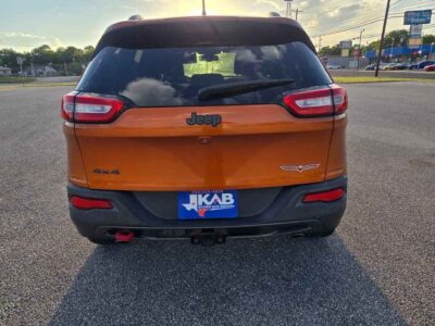Rear overview layout of 2015 Jeep Cherokee Trailhawk showing red signature recovery tow hooks, class hitch receiver, and premium dark badging